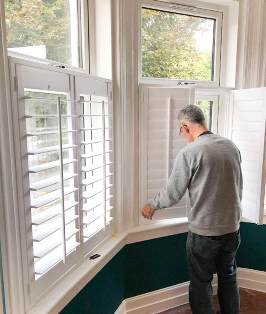 Window Shutter installation Bathgate by Stylerite-Blinds, Livingston, West Lothian. An image of a joiner installing wooden shutter blinds.